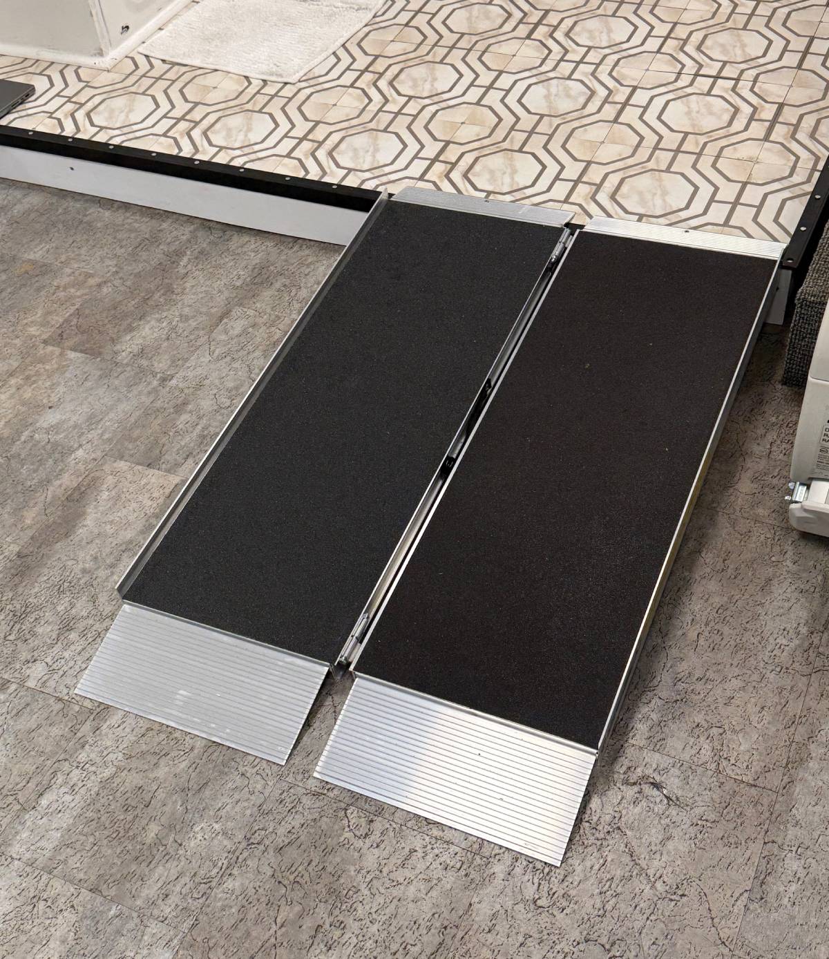 a portable ramp leading from tile to a raised area